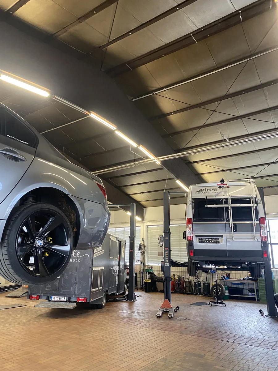 BMW und Pössl Wohnmobil auf benachbarten Hebebühnen