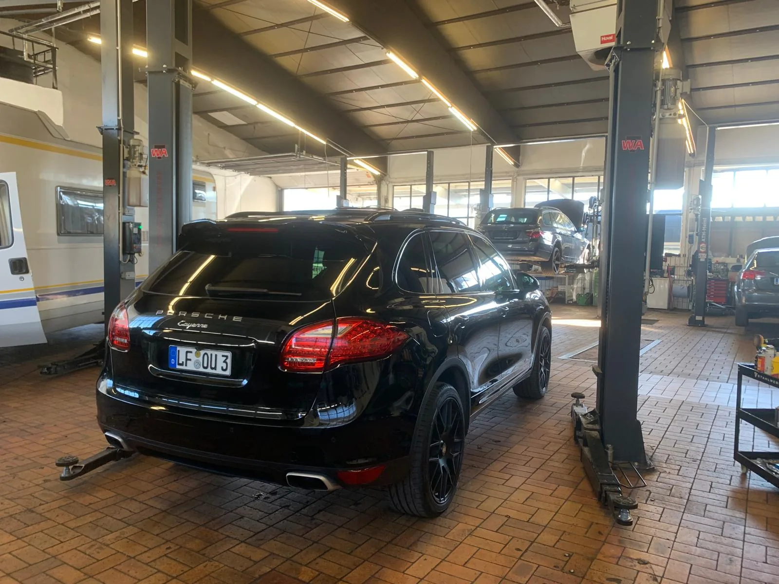 Schwarzer Porsche Cayenne in der CTC Werkstatt bei der Inspektion